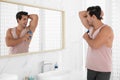 Handsome  man applying deodorant in bathroom Royalty Free Stock Photo