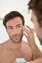 Handsome man applying facial cream Royalty Free Stock Photo