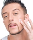 Handsome man applying male creme on face Royalty Free Stock Photo