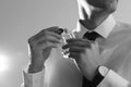 Handsome man applying perfume on neck against light background. Black and white effect Royalty Free Stock Photo