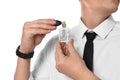 Handsome man applying perfume on neck against white background Royalty Free Stock Photo