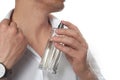 Handsome man applying perfume on neck against white background Royalty Free Stock Photo