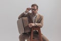 Handsome man arranging his glasses, holding his luggage Royalty Free Stock Photo