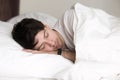 Handsome man asleep in bed wearing wristband for sleep tracking