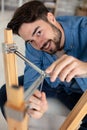 handsome man assembling furniture in new apartment and tightening screw Royalty Free Stock Photo