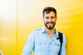 Handsome man with backpack on yellow Royalty Free Stock Photo