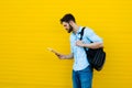 Handsome man with backpack on yellow Royalty Free Stock Photo