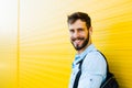 Handsome man with backpack on yellow Royalty Free Stock Photo
