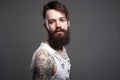 Bearded hipster. Boy with stylish haircut and tattoo