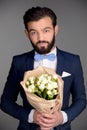 Handsome man with beard holding bouquet of flowers Royalty Free Stock Photo