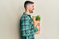 Handsome man with beard holding paper bag with groceries looking to side, relax profile pose with natural face and confident smile