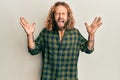 Handsome man with beard and long hair wearing casual clothes celebrating mad and crazy for success with arms raised and closed