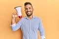 Handsome man with beard shouting through megaphone smiling with a happy and cool smile on face Royalty Free Stock Photo