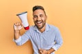 Handsome man with beard shouting through megaphone smiling and laughing hard out loud because funny crazy joke Royalty Free Stock Photo