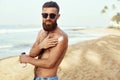 Handsome Man with beard, In Sunglasses Sunbathing With Sunscreen Lotion Body In Summer. Male Fitness Model Tanning Using Solar Blo Royalty Free Stock Photo