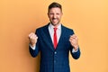 Handsome man with beard wearing business suit and tie very happy and excited doing winner gesture with arms raised, smiling and Royalty Free Stock Photo