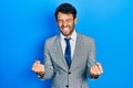 Handsome man with beard wearing business suit and tie very happy and excited doing winner gesture with arms raised, smiling and Royalty Free Stock Photo