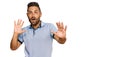 Handsome man with beard wearing casual clothes afraid and terrified with fear expression stop gesture with hands, shouting in Royalty Free Stock Photo