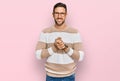 Handsome man with beard wearing casual clothes and glasses with hands together and crossed fingers smiling relaxed and cheerful Royalty Free Stock Photo