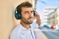 Handsome man with beard wearing headphones and enjoying listening to music outdoors Royalty Free Stock Photo