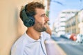 Handsome man with beard wearing headphones and enjoying listening to music outdoors Royalty Free Stock Photo