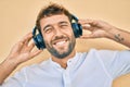 Handsome man with beard wearing headphones and enjoying listening to music outdoors Royalty Free Stock Photo