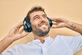 Handsome man with beard wearing headphones and enjoying listening to music outdoors Royalty Free Stock Photo