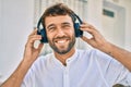 Handsome man with beard wearing headphones and enjoying listening to music outdoors Royalty Free Stock Photo