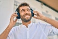 Handsome man with beard wearing headphones and enjoying listening to music outdoors Royalty Free Stock Photo