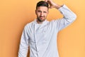 Handsome man with beard wearing professional cook uniform confuse and wonder about question
