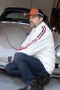 Handsome man with beard in white leather sport race jacket aside retro racing car vintage with cap fashion lifestyle Royalty Free Stock Photo