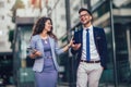 Young man and beautiful woman as business partners using digital tablet outdoor Royalty Free Stock Photo