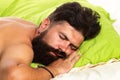Handsome man in bed. Bearded man sleeping on bed in bedroom. Good morning. Young man sleeping in bed with pillows at Royalty Free Stock Photo