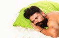 Handsome man in bed. Bearded man sleeping on bed in bedroom. Good morning. Young man sleeping in bed with pillows at Royalty Free Stock Photo