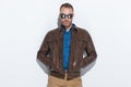 Handsome man being cool, wearing sunglasses and brown leather jacket Royalty Free Stock Photo