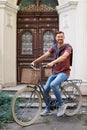 Handsome man with bicycle near ornate door