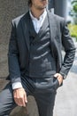 Handsome man in black formal suit and yellow sunglasses standing on the stairs and keeping his hands in his pockets. Royalty Free Stock Photo