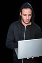 Handsome man in black hoodie using laptop Royalty Free Stock Photo