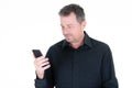 Handsome man in black shirt is looking at the screen of his phone smartphone Royalty Free Stock Photo
