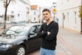 Handsome man in a black T-shirt near a car in the city Royalty Free Stock Photo