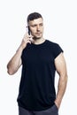 A handsome man in a black t-shirt is talking on the phone. Career, business and success. Isolated on white background. Vertical Royalty Free Stock Photo
