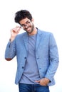 Handsome man in blue blazer standing with hand on glasses
