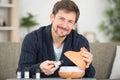 handsome man with bottle perfume on light background