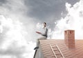 Handsome man on brick roof against cloud scape reading book Royalty Free Stock Photo