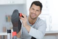 Handsome man with brush cleaning black leather shoe Royalty Free Stock Photo