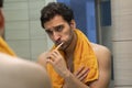 Handsome man brushing teeth and looking at the mirror in the bathroom Royalty Free Stock Photo