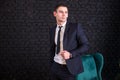 Handsome man in a business suit against a black brick wall, model photo. Succesful fashionable man Royalty Free Stock Photo