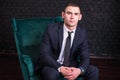 Handsome man in a business suit against a black brick wall, model photo. Succesful fashionable man