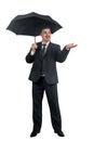 A handsome man businessman in a suit stands under an umbrella and smiles