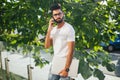 Handsome indian man cell phone call smile outdoor city street. Young attractive businessman casual blue shirt talking Royalty Free Stock Photo